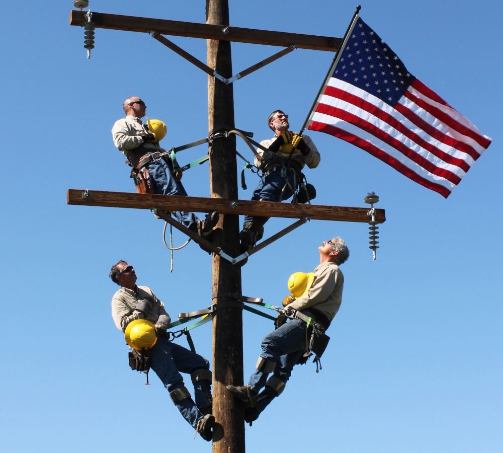 Employees climbing pole on Veterans' Day